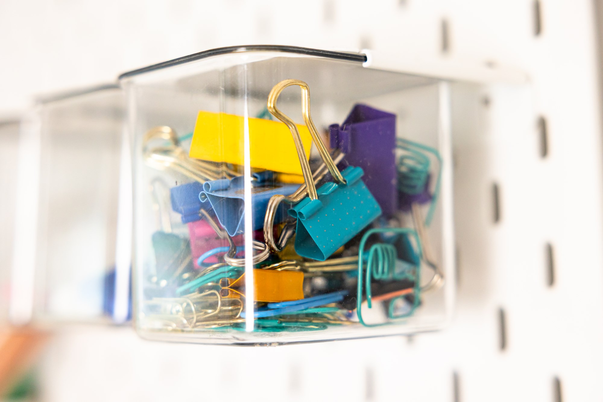Colourful clips organised in clear container