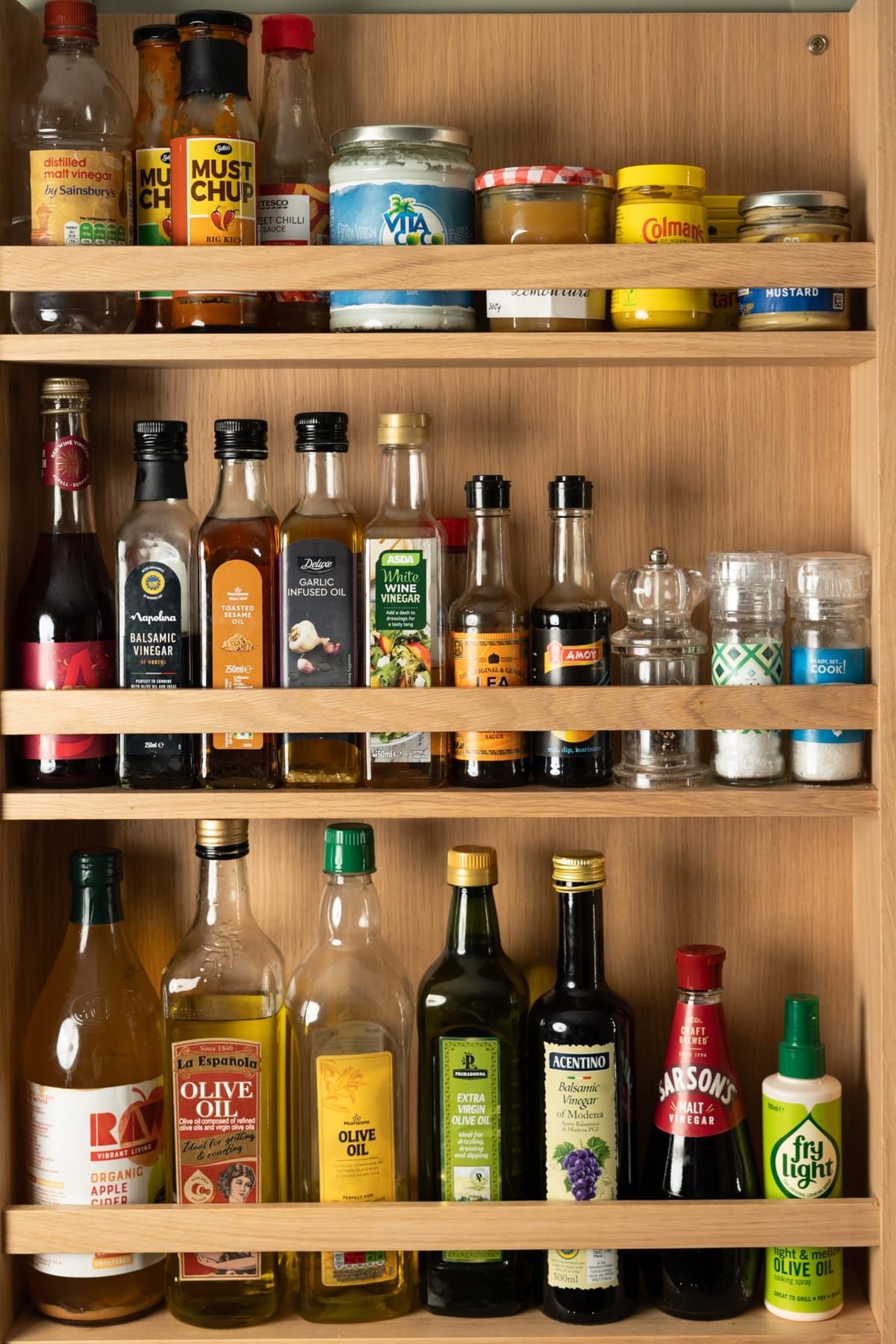 Organised cupboard with oils, vinegars and condiments