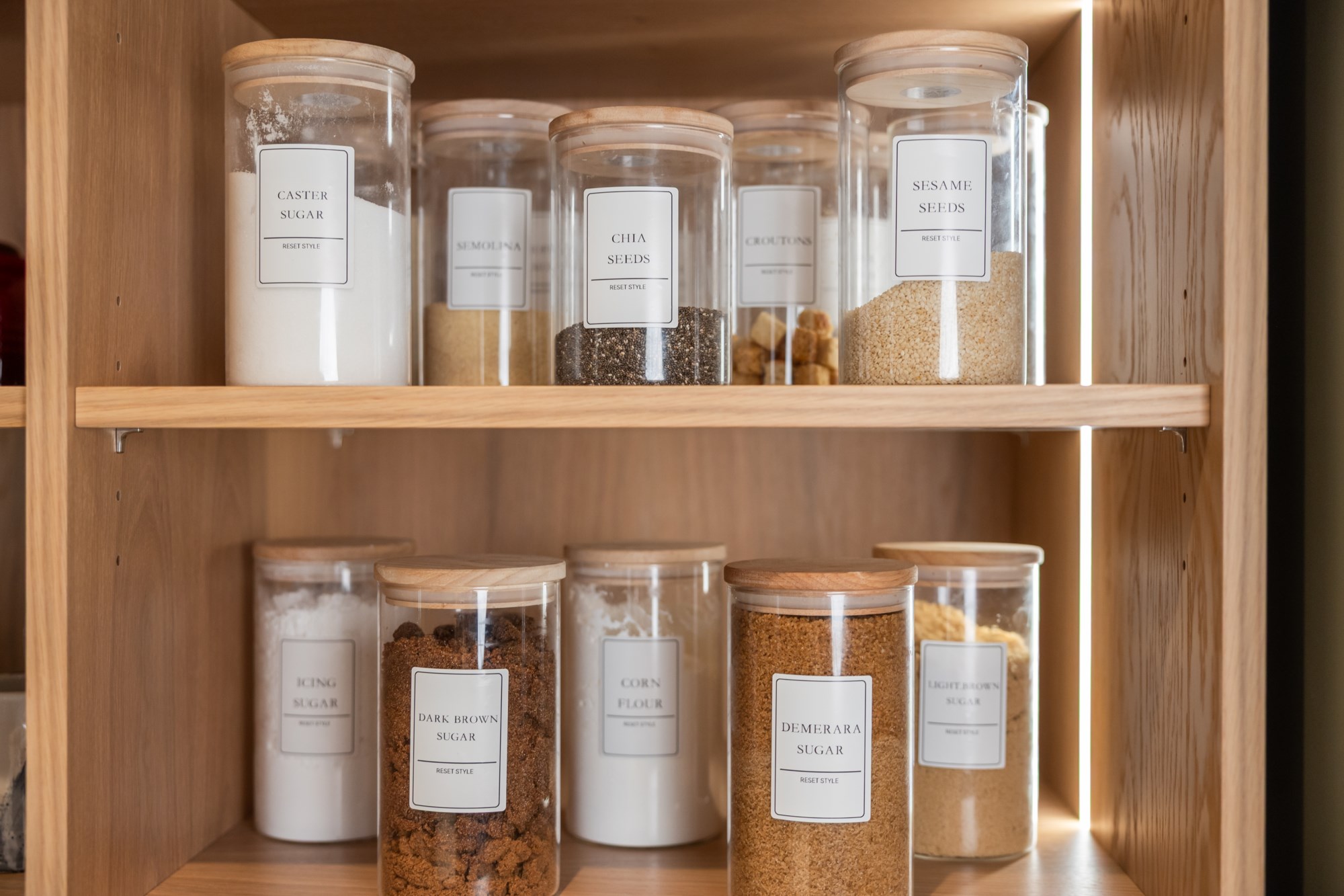 Organised pantry shelves with labelled glass jars
