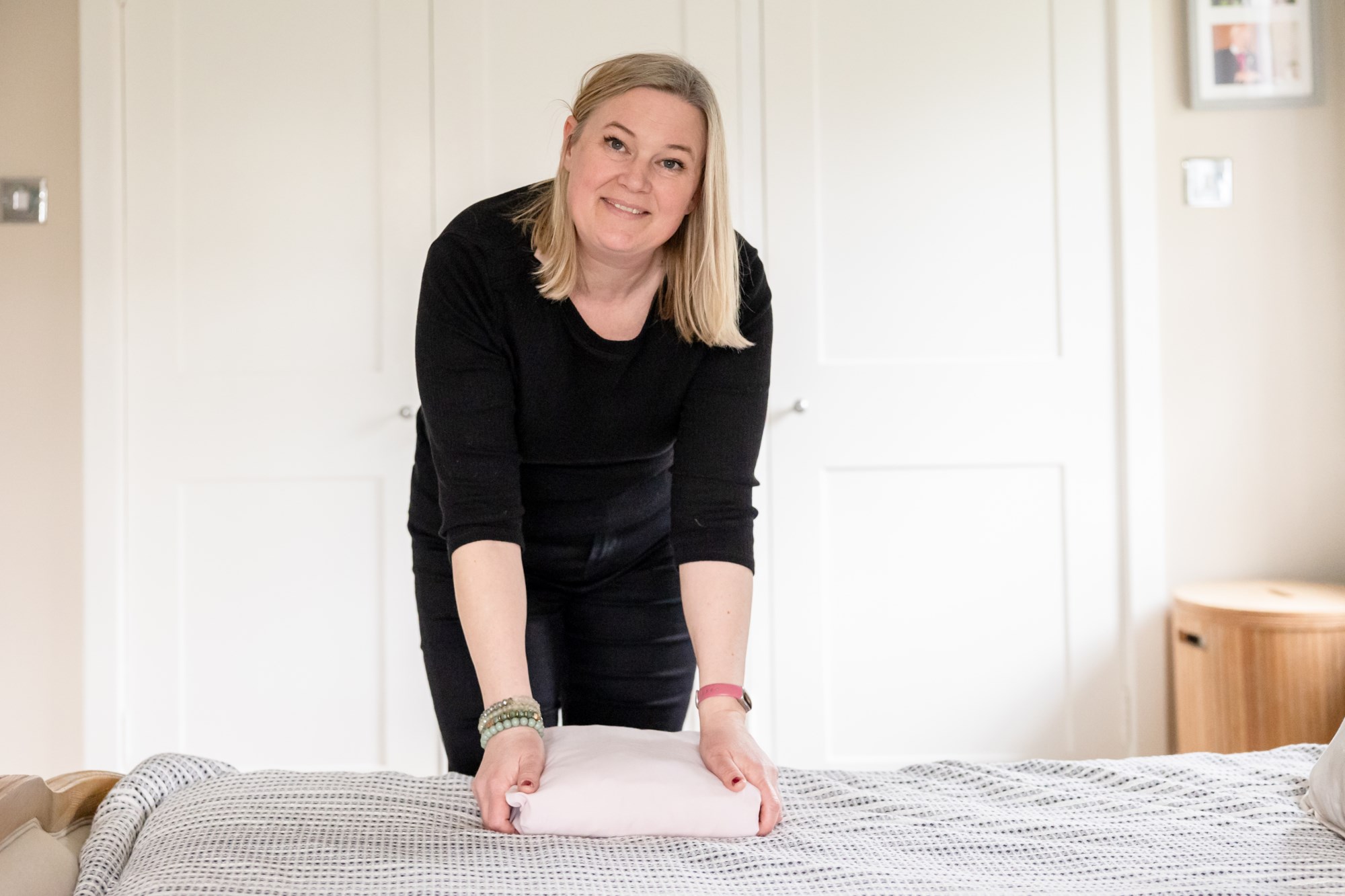 Organiser folding clothes on bed