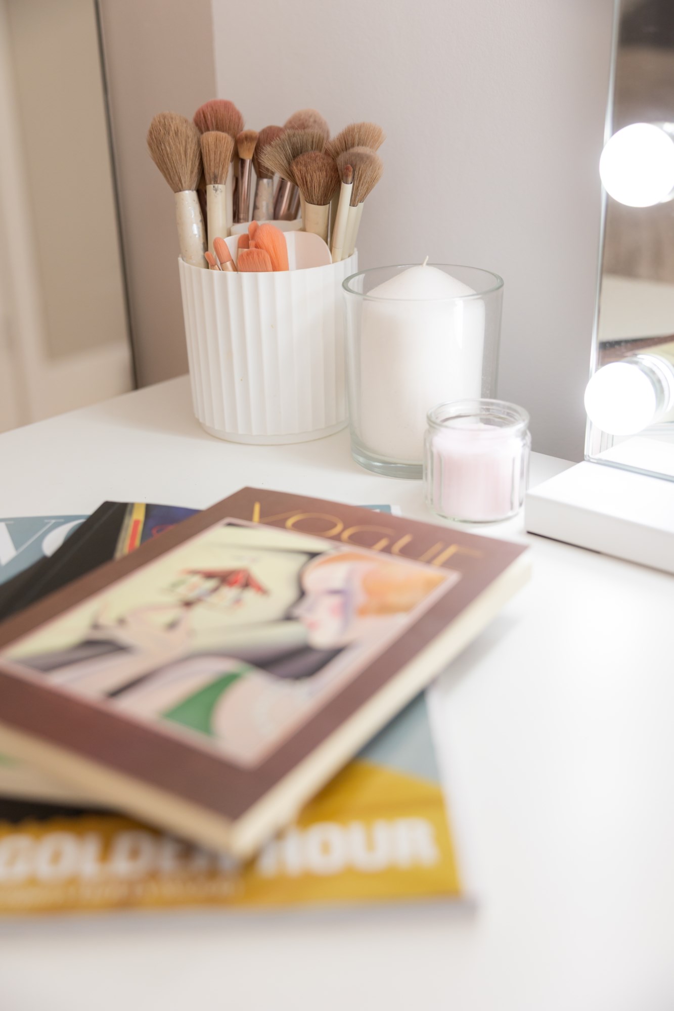 Styled vanity with makeup brushes and candles